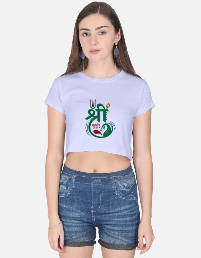 Woman wearing a lavender crop top featuring a spiritual Devanagari "Shree Mukund" graphic print on the front with tilak and peacock feather motifs.