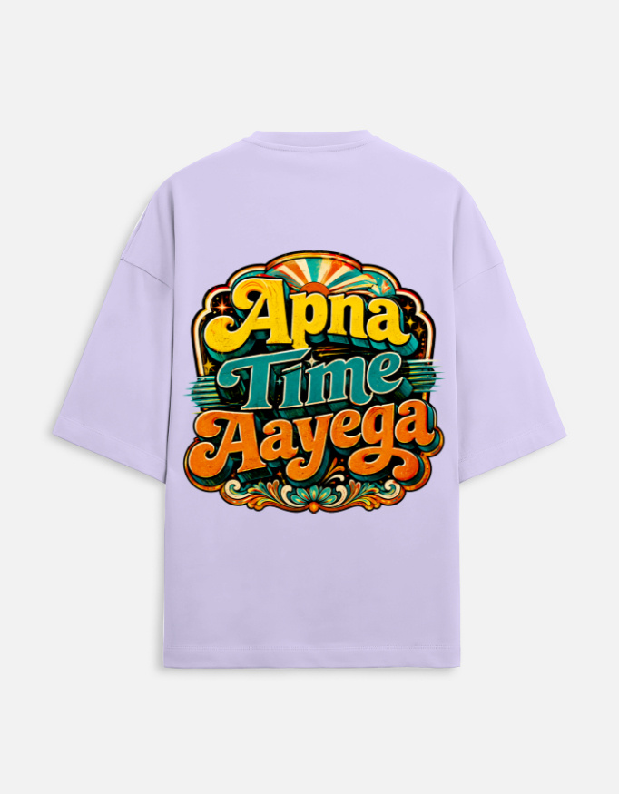 Unisex lavender terry oversized t-shirt featuring a vibrant retro psychedelic typography print on the back with the phrase "Apna Time Aayega" in bold yellow, teal, and orange letters.