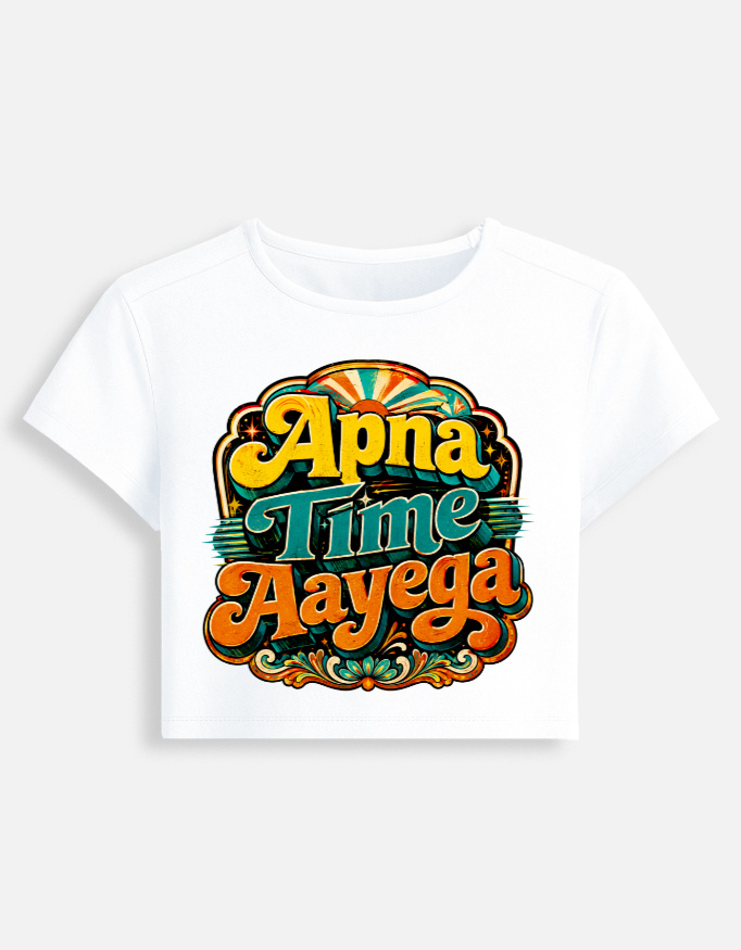 White fitted baby tee featuring a vibrant retro psychedelic typography print on the front with the phrase "Apna Time Aayega" in bold yellow, teal, and orange letters.