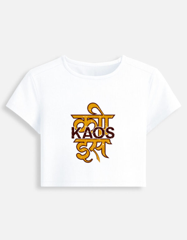 White fitted baby tee featuring a yellow Devanagari script typography graphic on the front with "KAOS" printed across it.