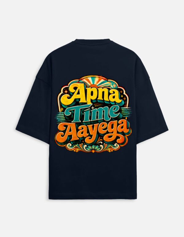 Unisex navy blue terry oversized t-shirt featuring a vibrant retro psychedelic typography print on the back with the phrase "Apna Time Aayega" in bold yellow, teal, and orange letters.