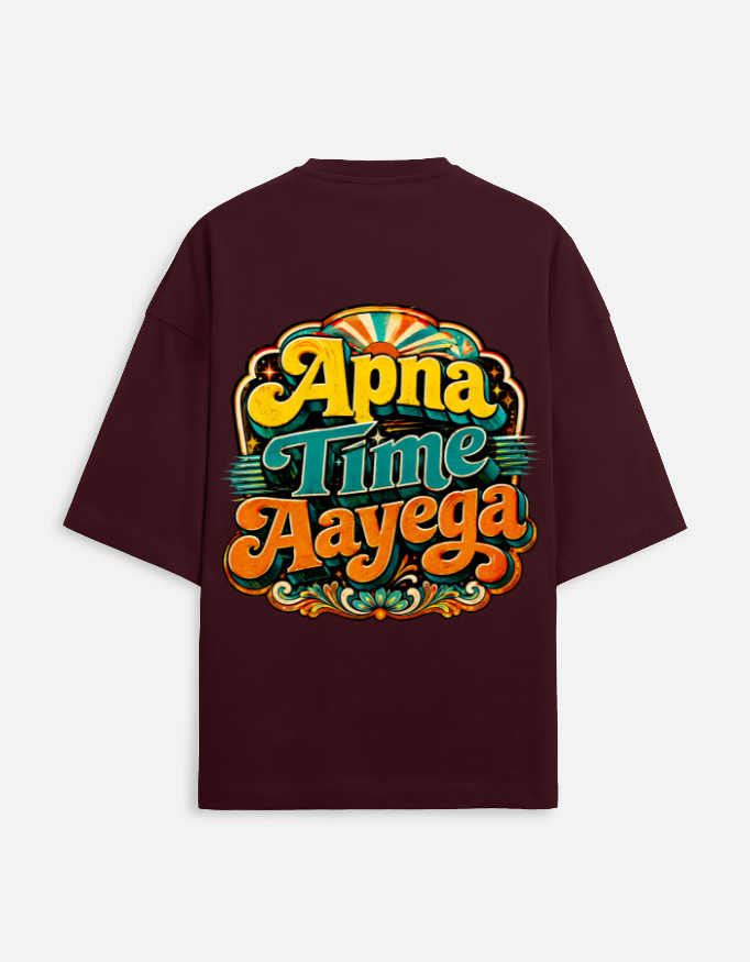 Unisex maroon terry oversized t-shirt featuring a vibrant retro psychedelic typography print on the back with the phrase "Apna Time Aayega" in bold yellow, teal, and orange letters.