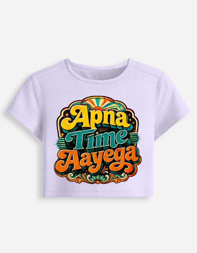 Lavender fitted baby tee featuring a vibrant retro psychedelic typography print on the front with the phrase "Apna Time Aayega" in bold yellow, teal, and orange letters.