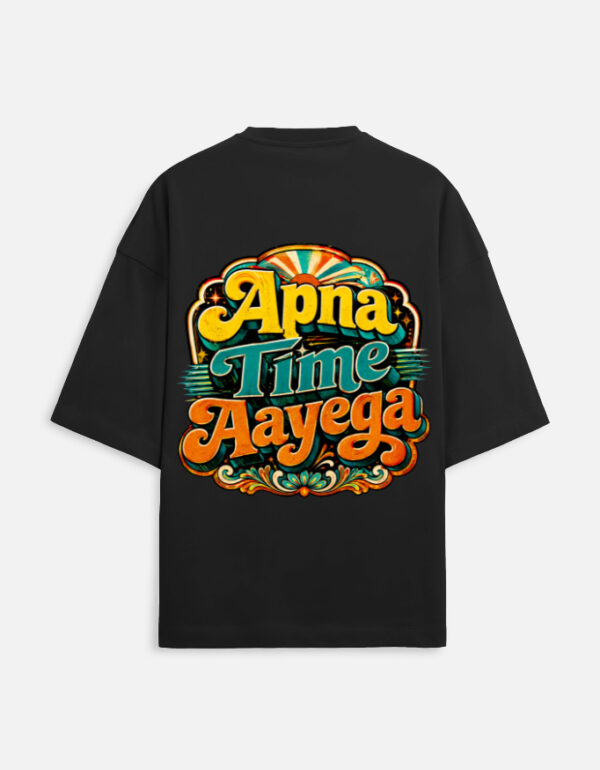 Unisex black terry oversized t-shirt featuring a vibrant retro psychedelic typography print on the back with the phrase "Apna Time Aayega" in bold yellow, teal, and orange letters.
