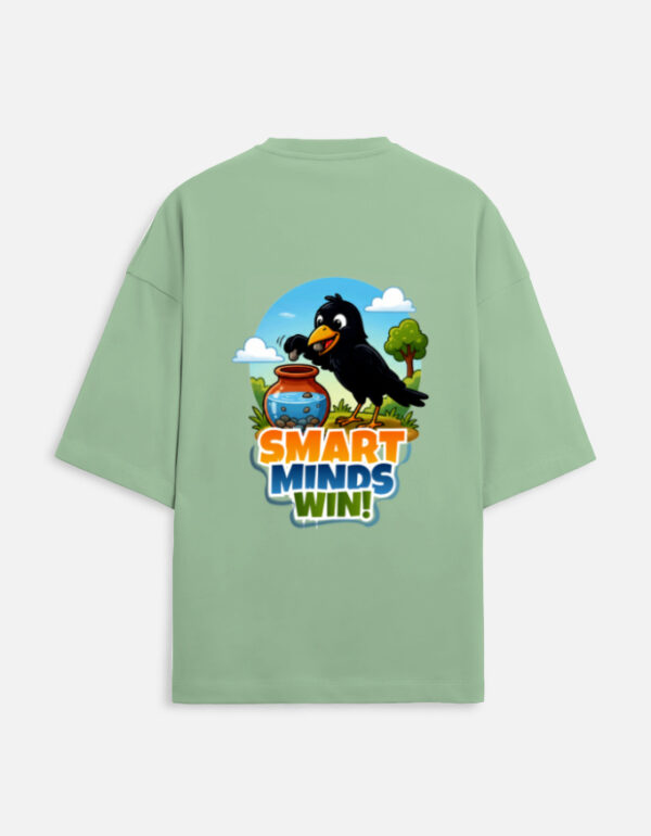 Unisex jade green terry oversized t-shirt featuring a colorful cartoon graphic on the back of a thirsty crow putting pebbles into a water pot with "Smart Minds Win!" text.