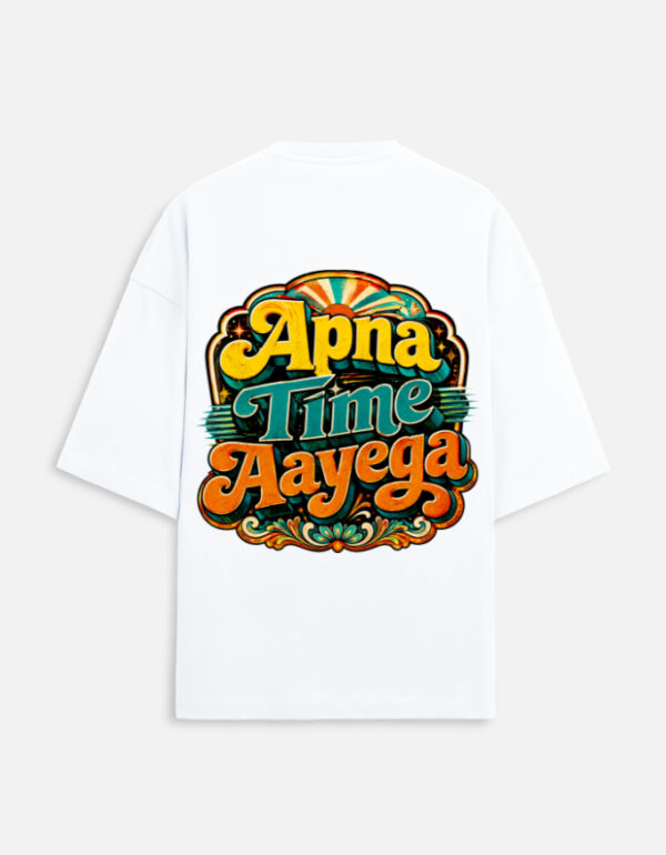 Unisex white terry oversized t-shirt featuring a vibrant retro psychedelic typography print on the back with the phrase "Apna Time Aayega" in bold yellow, teal, and orange letters.