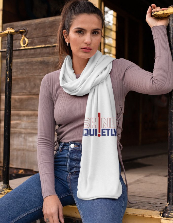 Vertical flat lay view of a white poly-woven satin stole featuring a red bar element with outlined and bold typography reading "SHINE QUIETLY".